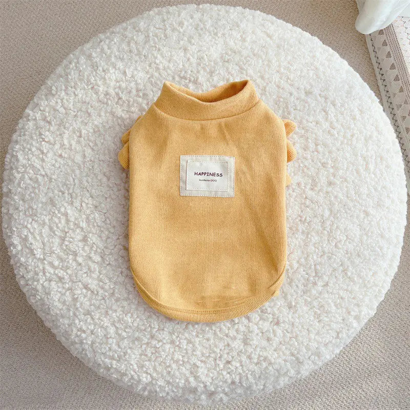 Small dog wearing knit sweater with flying sleeves princess style in yellow